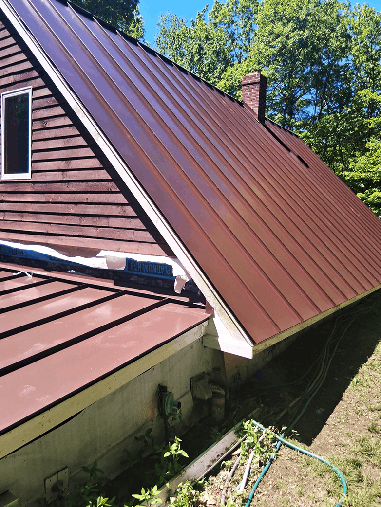 Red standing seam metal roof paired with custom-fit standing seam gutters