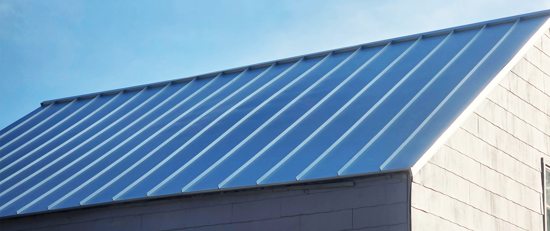 Standing seam gutter replacement installed flush against a metal roof edge