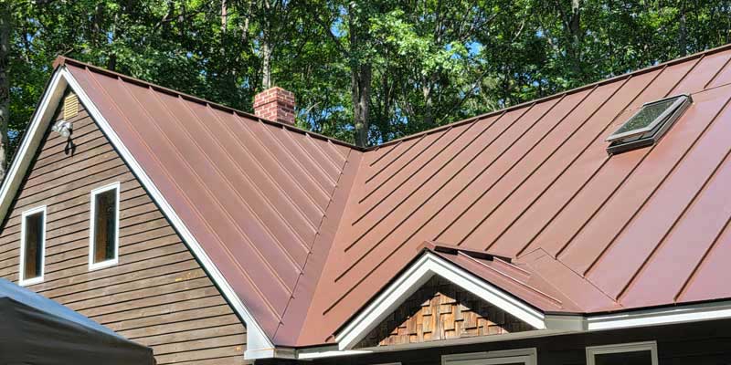 Seamless gutters installed on a red standing seam metal roof, project photo 3