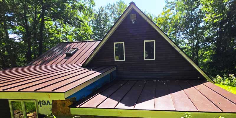 Seamless gutters installed on a red standing seam metal roof, project photo 4