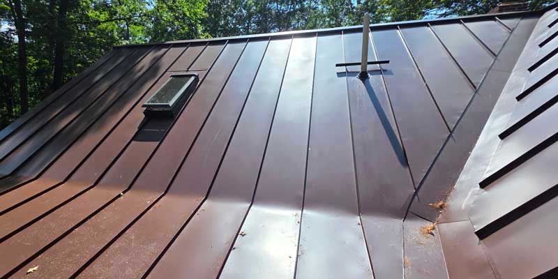 Seamless gutters installed on a red standing seam metal roof, project photo 5
