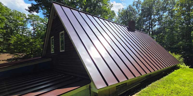 Seamless gutters installed on a red standing seam metal roof, project photo 6