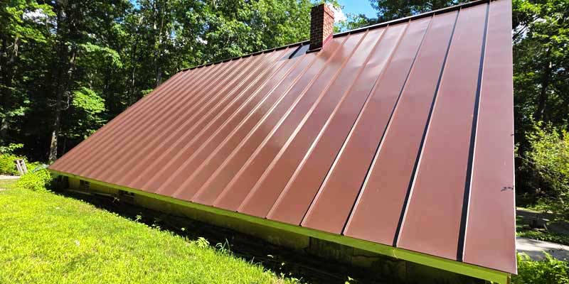 Seamless gutters installed on a red standing seam metal roof, project photo 8
