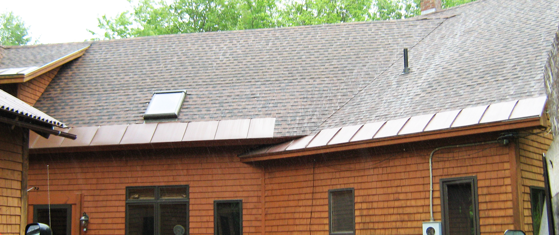 Standing seam snow belt metal roofing along the eaves of a log home